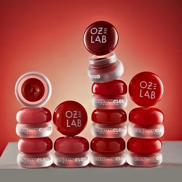 Stacked BonBon Cloud lip and cheek mousse jars on red